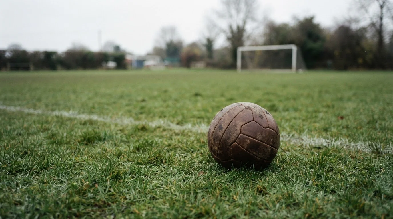 Fußball auf einem leeren Rasenfeld im weichen Tageslicht